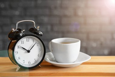 Ahşap arka plan klasik vintage çalar saat ve kahve fincanı