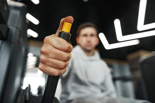 Jeune bodybuilder fit homme faisant entraînement d'armes dans la salle de gym sur la machine — Photo