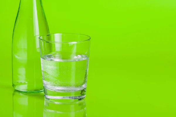 Agua mineral clara y pura sobre un fondo verde brillante — Foto de Stock