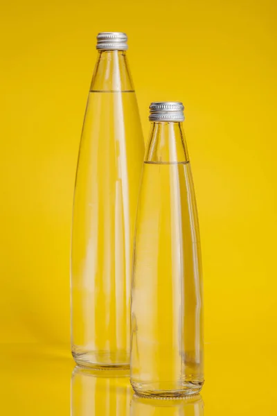 纯水在塑料瓶明亮的黄色背景 — 图库照片