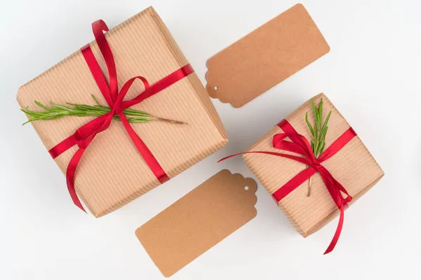 Gift boxes packed in craft paper with simple decor of green plant branches — Stock Photo, Image