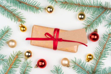 Noel hediyesi. Çam ağacı dalları ve küçük takılarla çevrili.