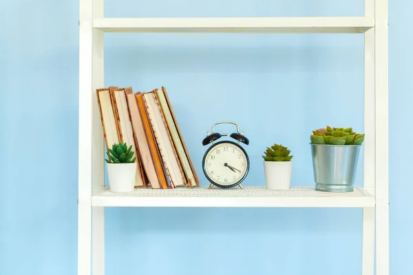 Perchero de metal blanco con libros sobre fondo azul —  Fotos de Stock