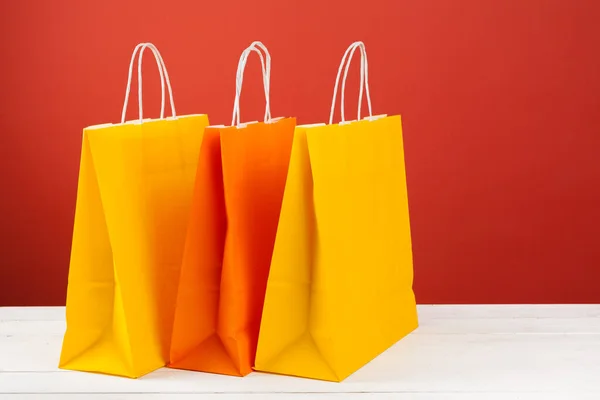 Bolsas de papel con espacio de copia sobre fondo rojo —  Fotos de Stock