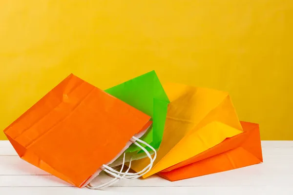 Arreglo de bolsas de compras sobre fondo amarillo brillante — Foto de Stock