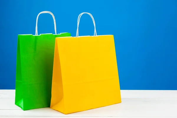 Sacos de compras de papel com espaço de cópia no fundo azul — Fotografia de Stock