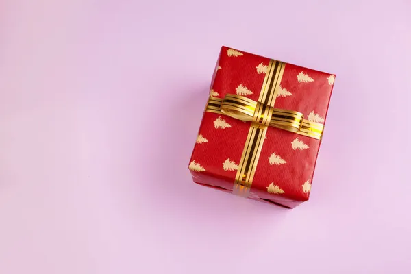 Top view of a decorated present with a bow on pink background — Stock Photo, Image