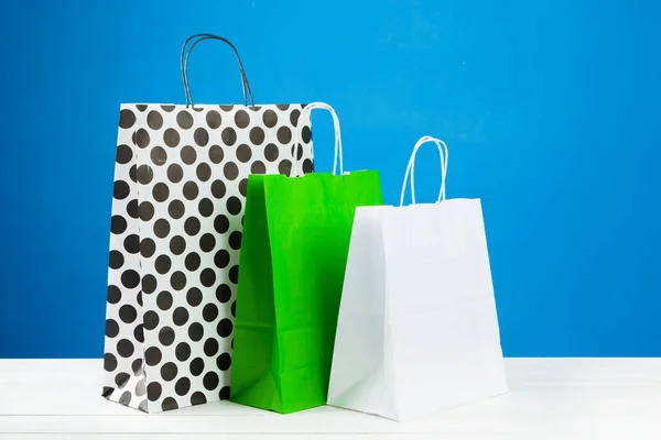 Arranjo de sacos de compras em fundo azul — Fotografia de Stock