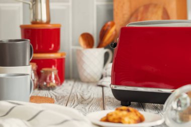 Mutfak rafında kırmızı çatal bıçak ve bulaşık takımı var.