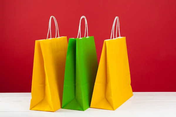 Vários sacos de compras com espaço de cópia no fundo vermelho — Fotografia de Stock
