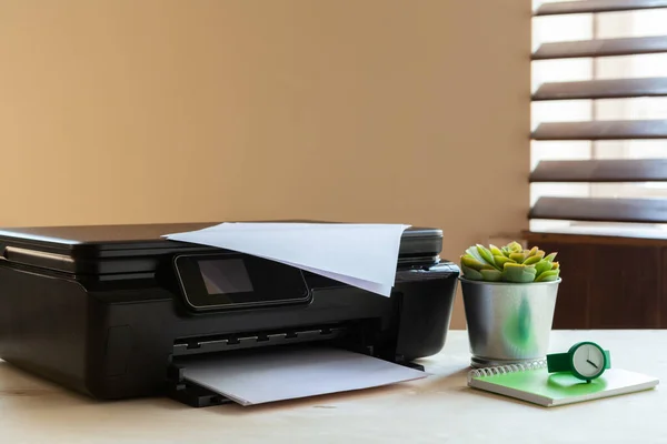 Vista frontal de una impresora negra sobre una mesa — Foto de Stock