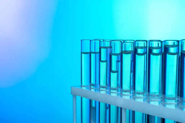 青と緑の色調の背景に液体と試験管の行 — ストック写真