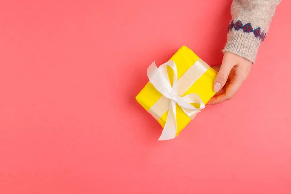 Vista superior de manos de mujer sosteniendo caja de regalo sobre fondo rosa —  Fotos de Stock