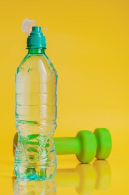 Parlak sarı arka plan üzerinde maden suyu Plastik şişe