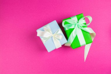 Pembe arka planı olan süslü bir hediyenin üst görünümü