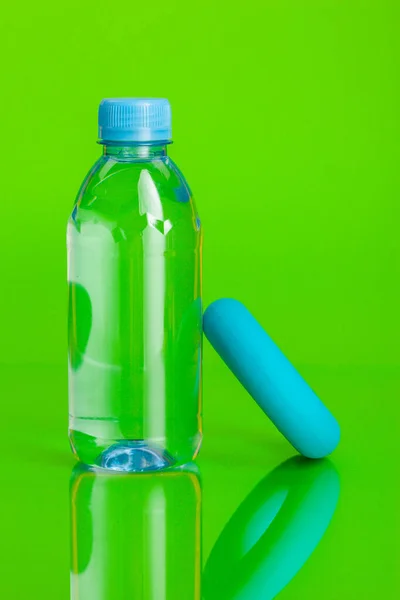 Kristallklart vatten i en flaska på grön bakgrund — Stockfoto