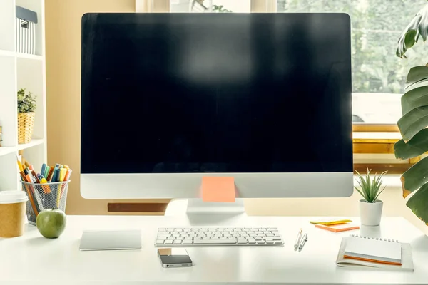 Oficina o espacio de trabajo en casa. Monitor de ordenador con pantalla negra en la mesa de oficina con suministros — Foto de Stock