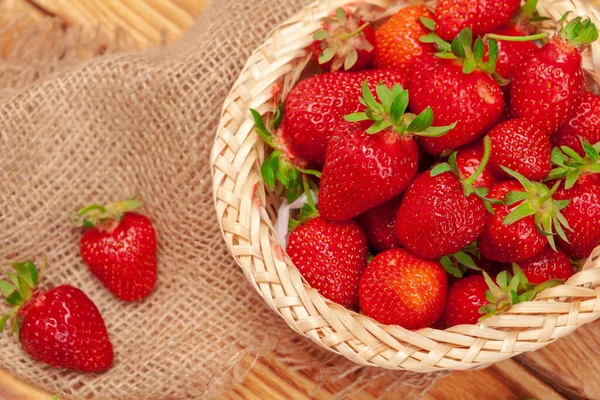 Basket of strawberry harvest on wooden table close up — Stock Photo, Image
