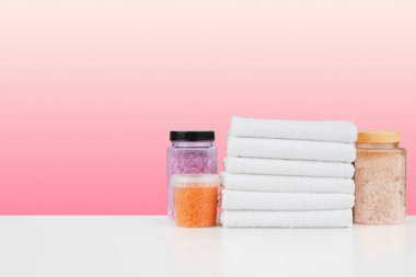 Banyo havluları ve spa tuzu beyaz masada.