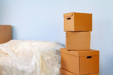 Ev eşyalarını kutulara koyup taşınmak için kanepeye tıkıştırdım.