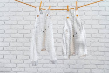 Şirin bebek renkli giysiler bir ipe asılmış.