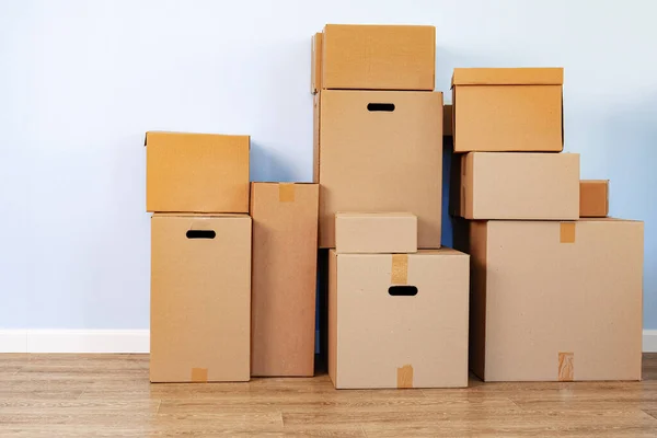 Concept de déménagement de maison avec des boîtes en carton empilées dans une pièce — Photo