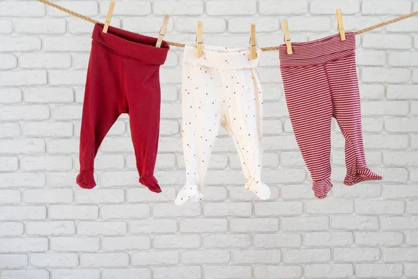 Wassen van babykleding vastgepind aan een touw om te drogen — Stockfoto