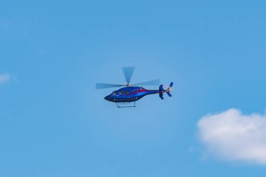 Güneşli bir günde gökyüzünde uçan helikopter.
