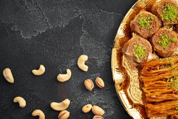 Heerlijke baklava dessert in oosterse setting op zwarte achtergrond — Stockfoto