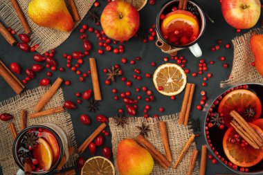 Siyah arka planda sıcak şarap ve baharatların üst görüntüsü