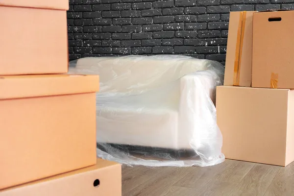 Moving in or moving out concept. Stack of boxes and packed furniture — Stock Photo, Image