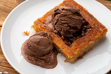 Türk tatlısı, ahşap arka planda dondurmayla servis edilir.