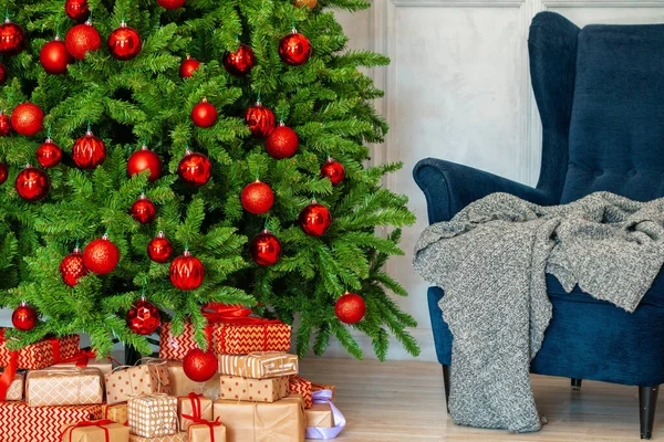 Interior de férias. Bela árvore de natal decorada com poltrona azul — Fotografia de Stock