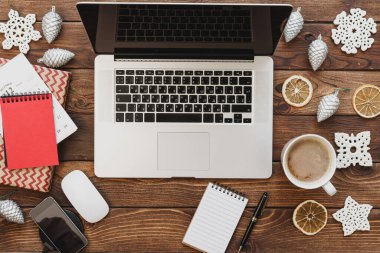 Ofis malzemeleri ve noel süslemeleri ile birlikte bilgisayarlı ahşap bir masaüstü manzarası