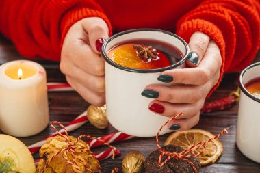 Elinde sıcak şarapla elinde bardak tutan bir kadın.