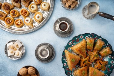 Açık mavi zemin üzerinde Türk tatlıları ve Türk kahvesi manzarası