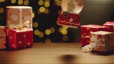 Noel kar küresi ve Noel hediyeleri masada