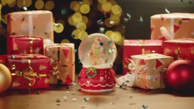 Noel kar küresi ve Noel hediyeleri masada