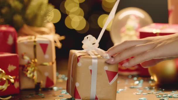 Női kéz kicsomagolása kis karácsonyi ajándék, közelről — Stock videók