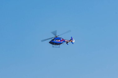 Güneşli bir günde gökyüzünde uçan helikopter.
