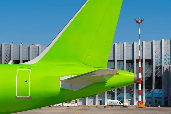 Avion de passagers vert à l'aéroport par temps ensoleillé — Photo
