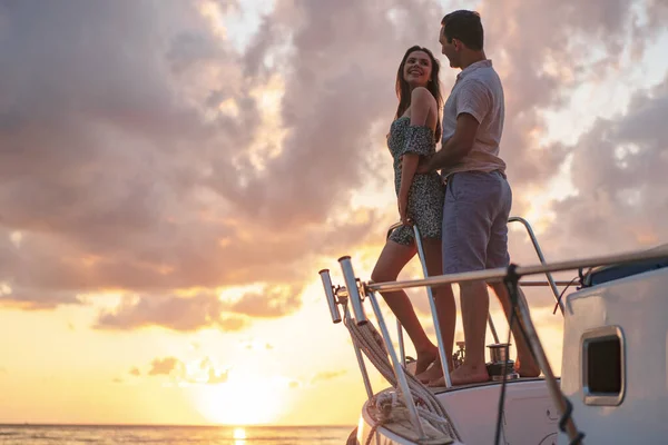 Красивая пара смотрит на закат с яхты — стоковое фото