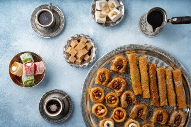 Açık mavi zemin üzerinde Türk tatlıları ve Türk kahvesi manzarası