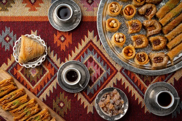 Café turco y dulces servidos en alfombra estampada de colores — Foto de Stock