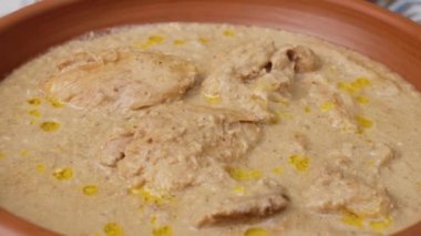 Krema sosunda pişirilmiş tavuk eti kil tabakta dönüyor.