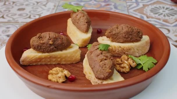 Broodschijfjes met paté op kleiplaat draaiend rond op tafel — Stockvideo