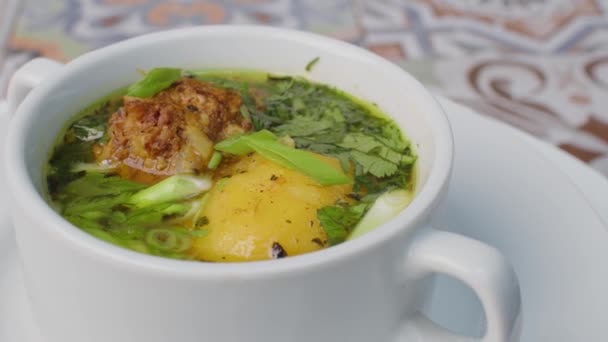 Kippensoep met aardappelen en kruiden ronddraaiend op tafel — Stockvideo