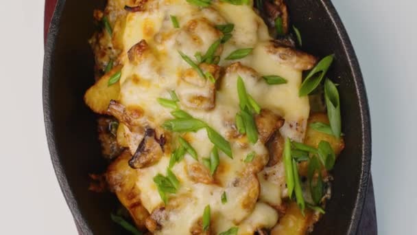 Smažené brambory s houbami a sýrem točící se na stole — Stock video