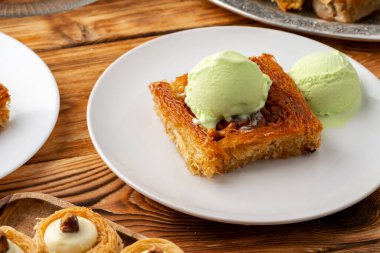 Türk tatlısı, ahşap arka planda dondurmayla servis edilir.