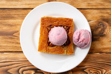 Türk tatlısı, ahşap arka planda dondurmayla servis edilir.